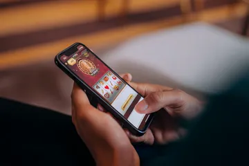 A cheerful woman in traditional clothing using her smartphone during a festive moment, showing how easily the OLYMP app fits into everyday life.