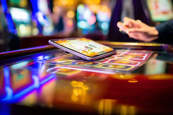 A person using their device against a moody casino-themed background, illustrating the smooth re-entry process at OLYMP.
